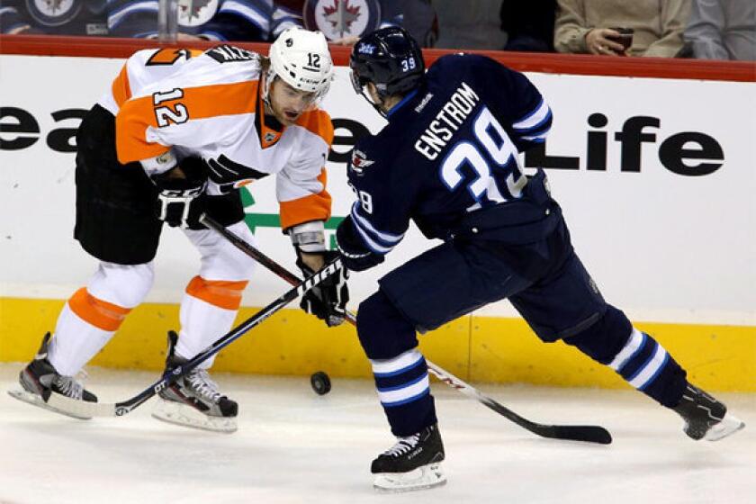 Harry Zolnierczyk (12) and Winnipeg Jets' Tobias Enstrom (39) battle for control of the puck.