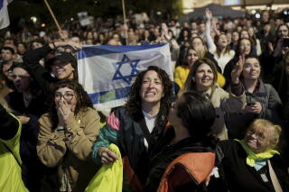 An emotional crowd gathers around an Israeli flag.