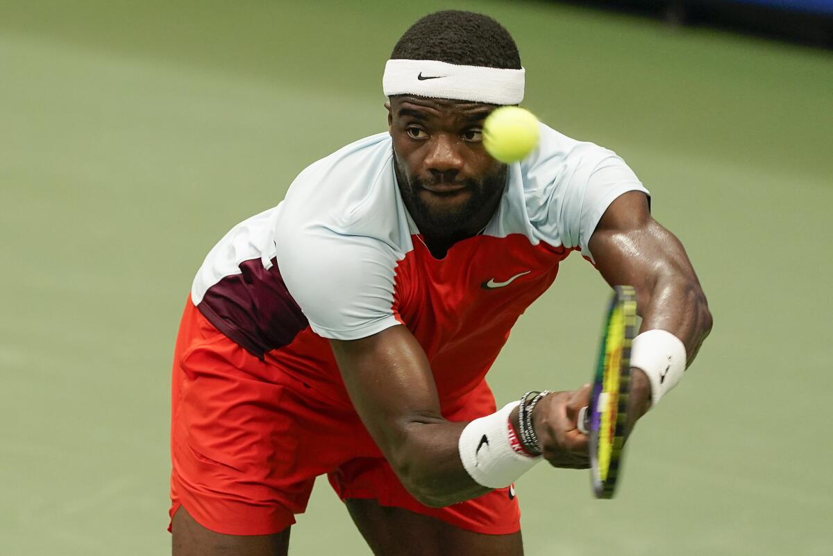 Frances Tiafoe returns a shot to Andrey Rublev.