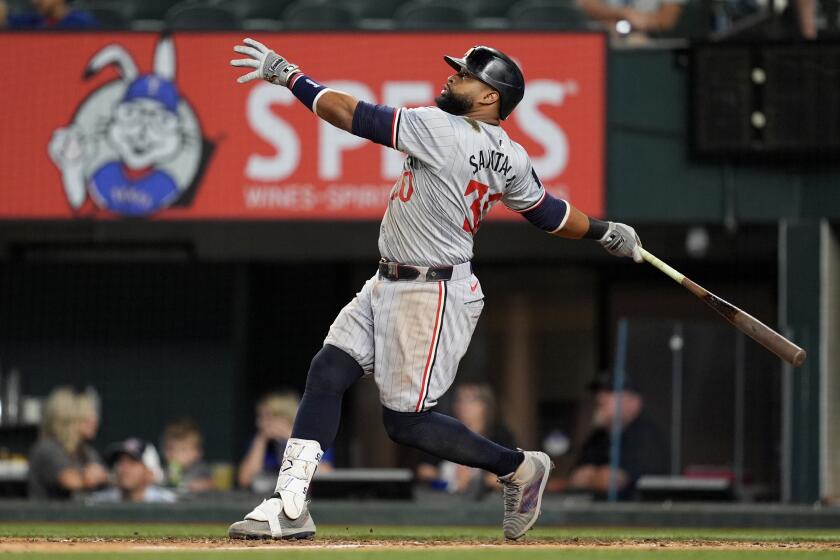 El dominicano Carlos Santana, de los Mellizos de Minnesota, conecta un elevado de sacrificio para empujar a Matt Wallner en el noveno inning del juego del jueves 15 de agosto de 2024, ante los Rangers de Texas (AP Foto/Tony Gutiérrez)