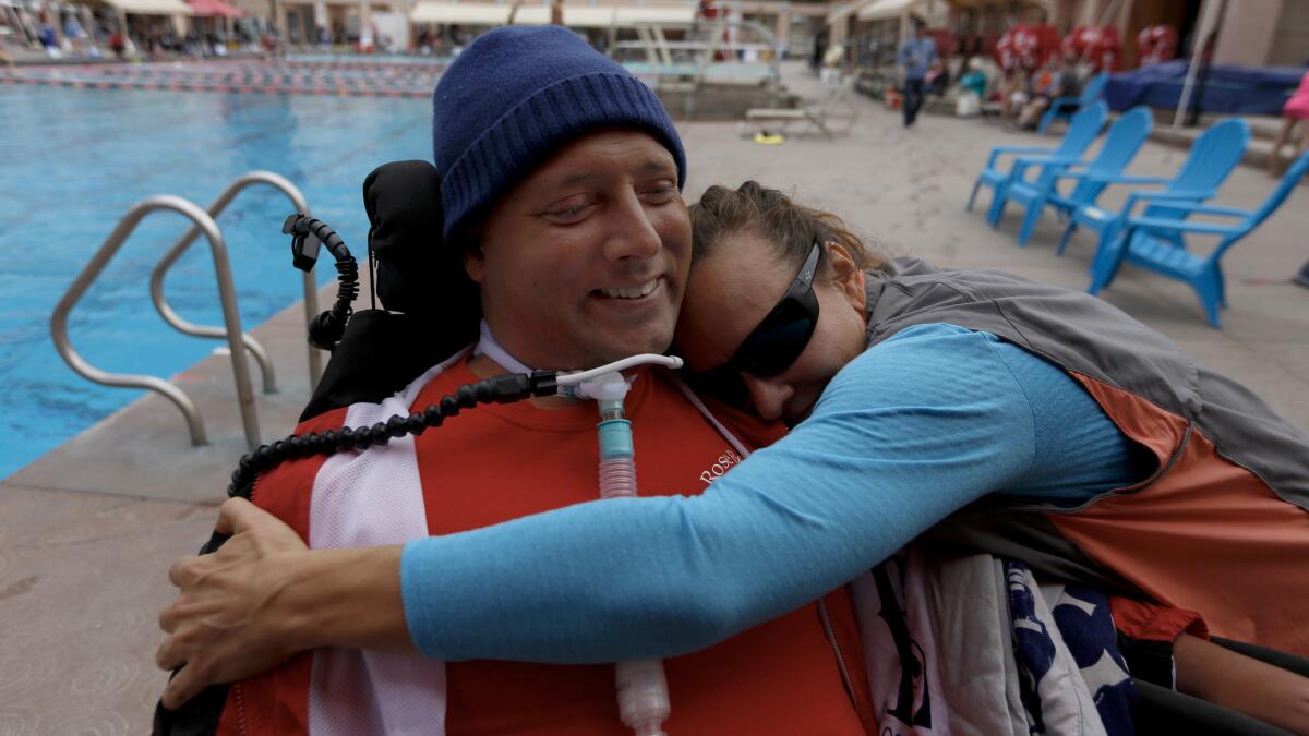 Diving coach Lenny Larsen of Pasadena gets a hug from Kelly Kerns, of Van Nuys at the Rose Bowl Aquatics Center in Pasadena.