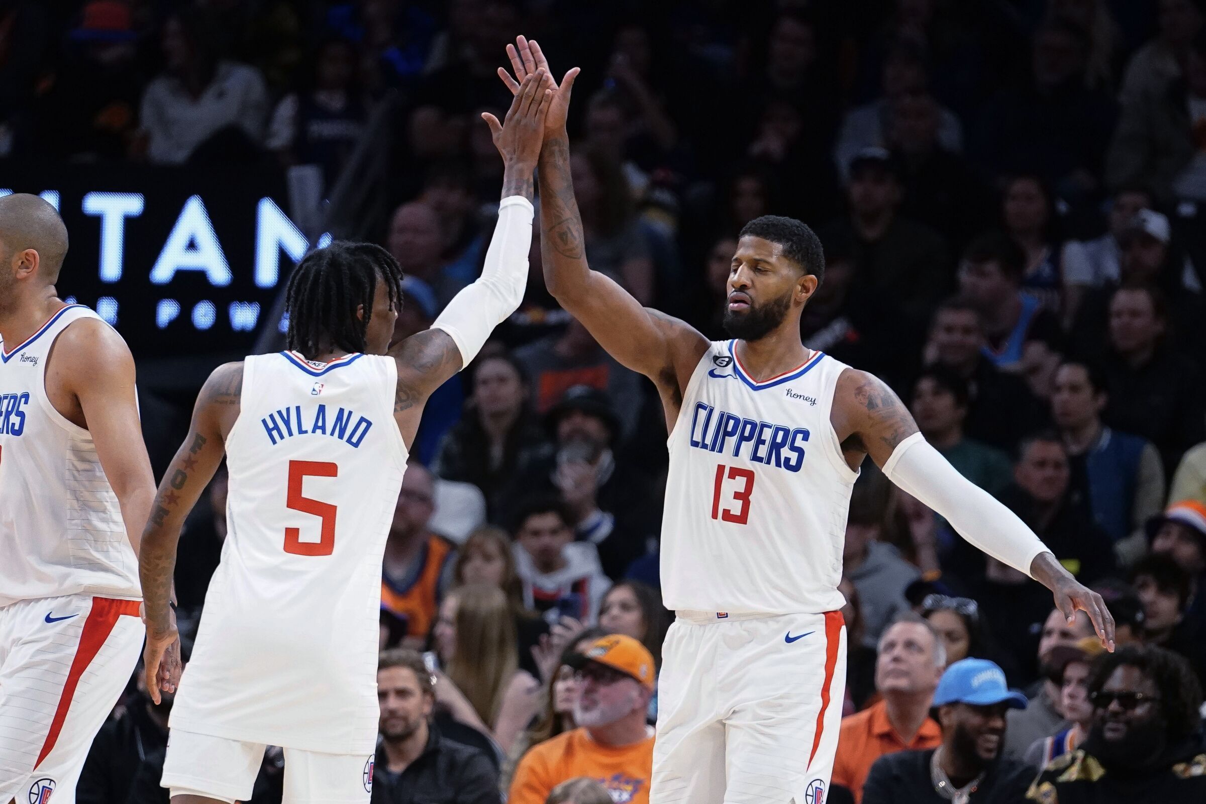 Clippers teammates Bones Hyland, left, and Paul George exchange high-fives during win over the Phoenix Suns on Feb. 16.