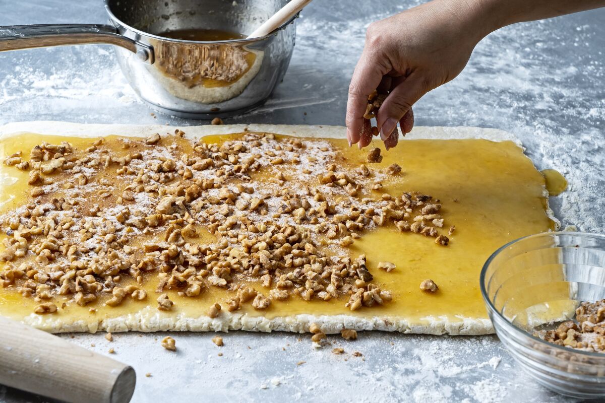 Chilled dough is covered with honey butter and sprinkled with a walnut-sugar mixture.