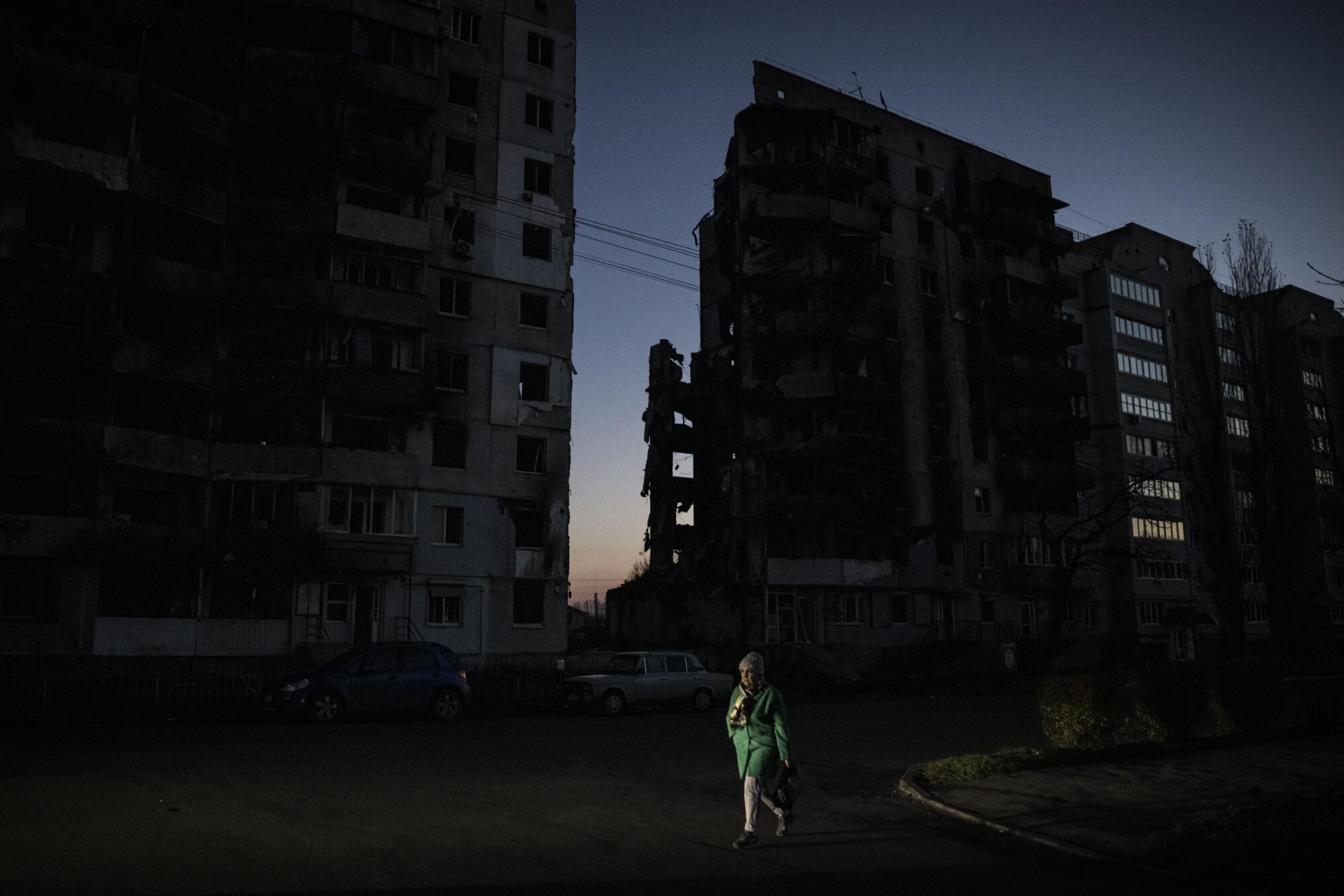 Damaged buildings silhouetted at dusk in Ukraine. 