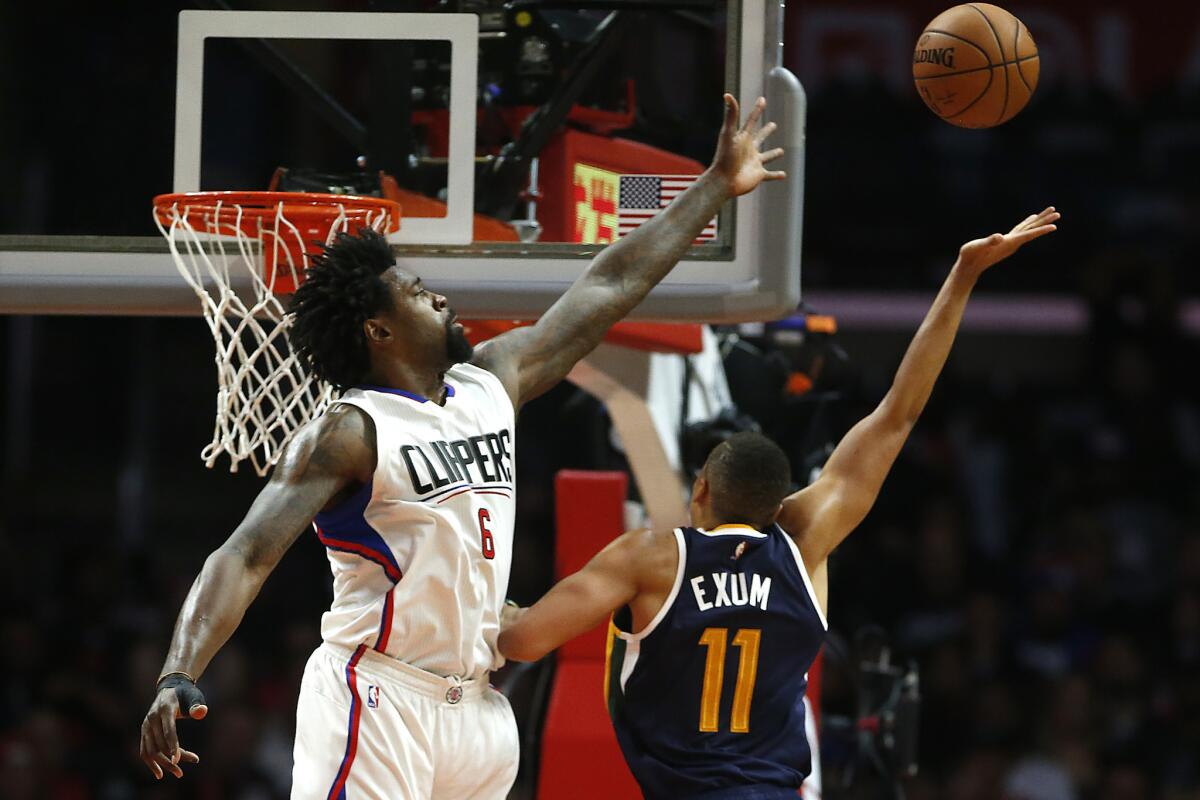 Clippers center DeAndre Jordan looks to block a shot by Utah center Dante Exum on Oct. 30.