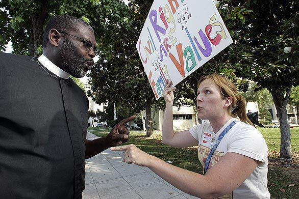 Associate Pastor Chauncey Killens, left, argues with demonstrator Vickye Ashton during a Sunday rally billed as a "Celebration of Marriage" at Fresno City Hall.