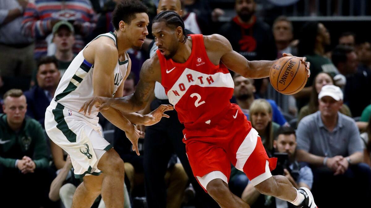 Toronto Raptors' Kawhi Leonard, right, dribbles the ball while being guarded by Milwaukee Bucks' Malcolm Brogdon in the fourth quarter during Game 5 of the Eastern Conference finals of the NBA playoffs on Thursday in Milwaukee.