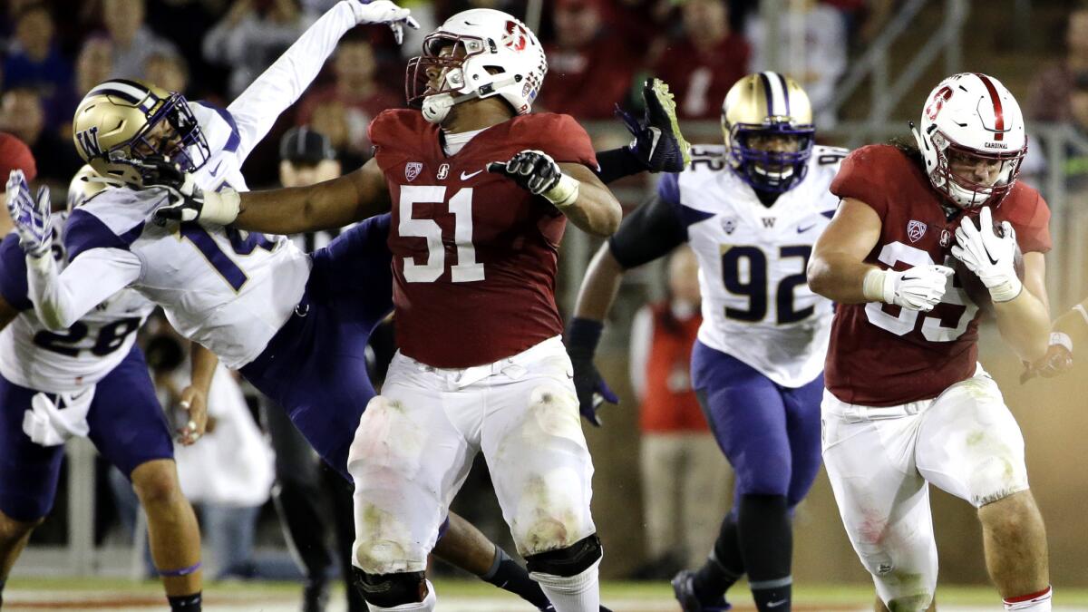 Stanford fullback Daniel Marx (35) runs as teammate Joshua Garnett (51) blocks Washington defensive back JoJo McIntosh (14) during the first half of an NCAA college football game Saturday, Oct. 24, 2015, in Stanford, Calif. (AP Photo/Marcio Jose Sanchez)