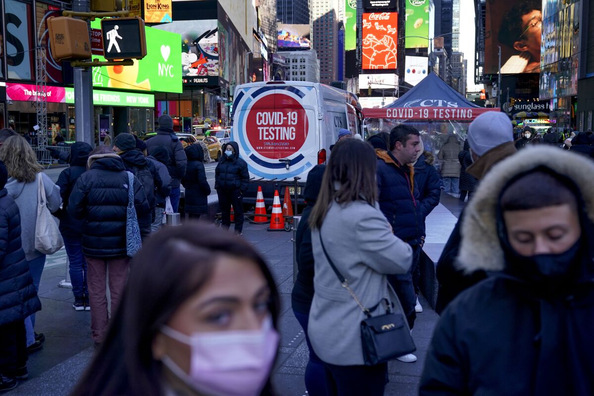 People wait in a long line to get tested for COVID-19 in New York City's Times Square. 