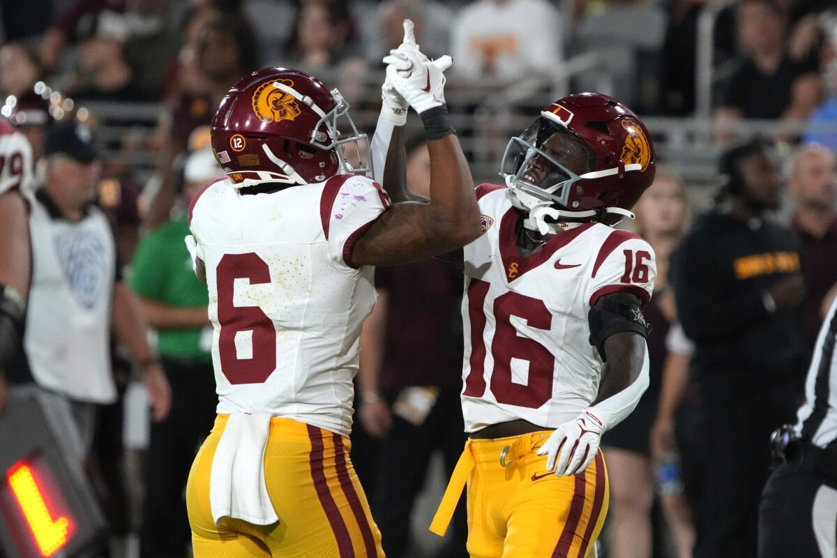 USC wide receiver Tahj Washington celebrates with running back Austin Jones after scoring on a 45-yard touchdown reception.
