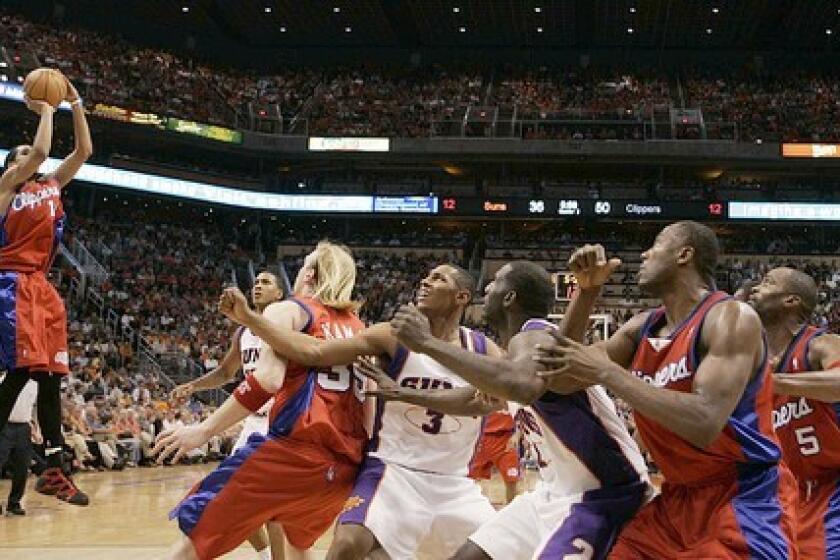 Clipper Shaun Livingston puts up two points as his teammates and the Phoenix Suns wait in unison for the rebound.
