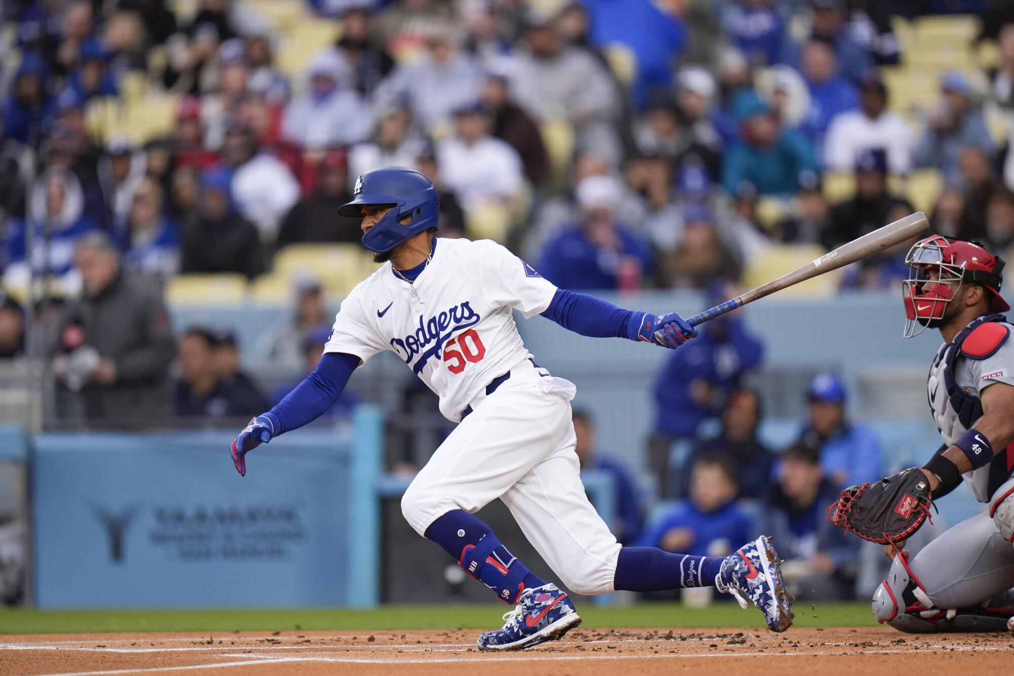 Dodgers shortstop Mookie Betts follows through with his swing after hitting a single during the first inning Saturday.