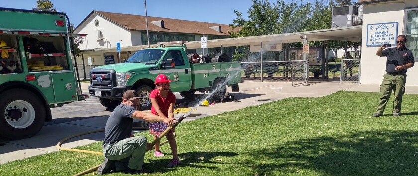 Alexandra Cedillo-Vargas, 7, sprays a firefighting hose at Ramona Elementary School.