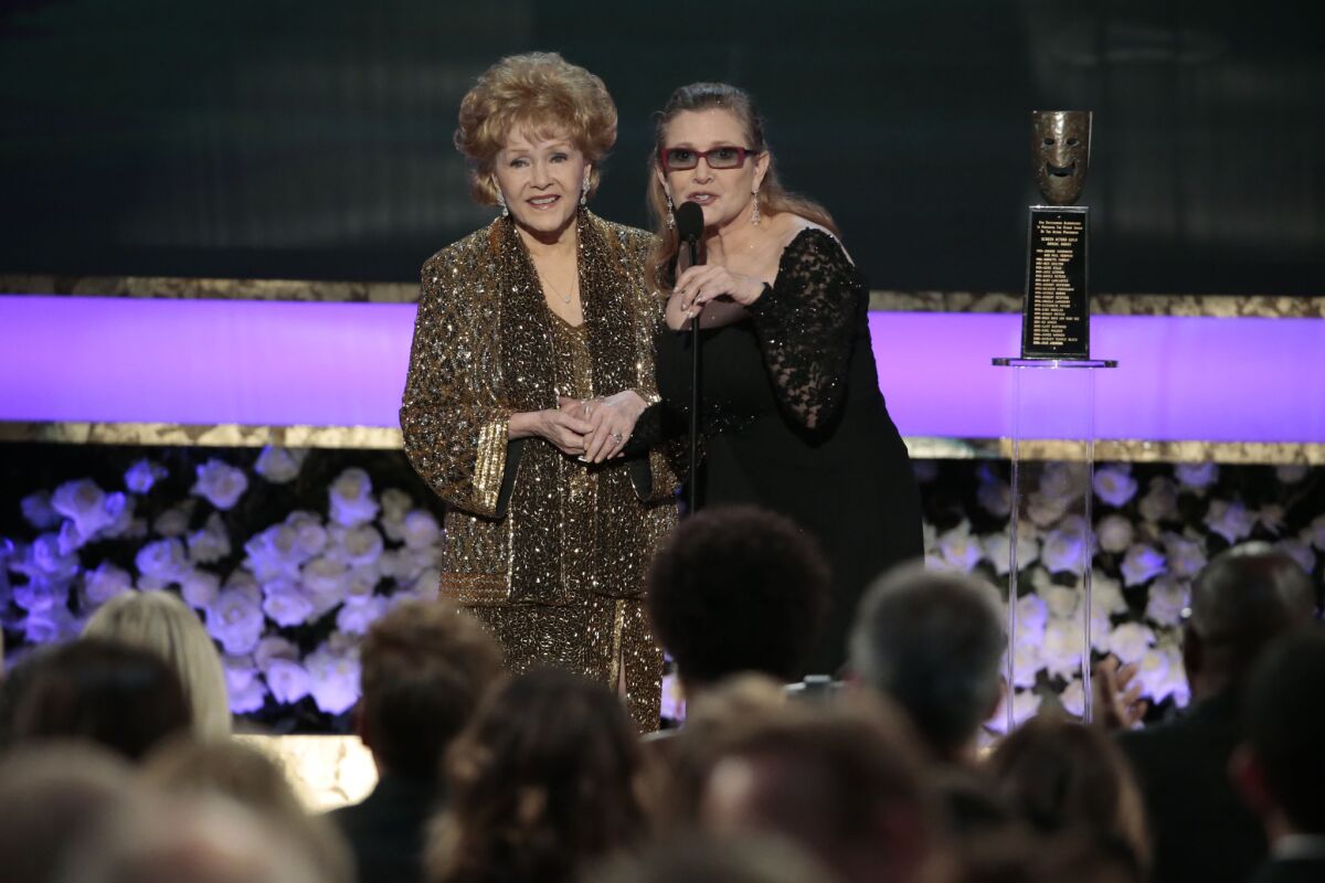 Carrie Fisher, right, who died Dec. 27, presents the Life Achievement Award to her mother, Debbie Reynolds, at the 21st Screen Actors Guild Awards at the Shrine Auditorium in Los Angeles on Jan. 25, 2015.