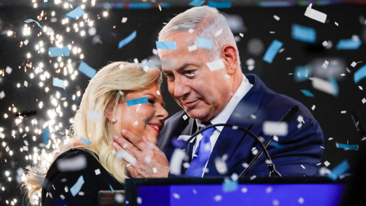 Prime Minister Benjamin Netanyahu embraces his wife Sara amid confetti and fireworks at Likud Party headquarters in Tel Aviv early Wednesday.