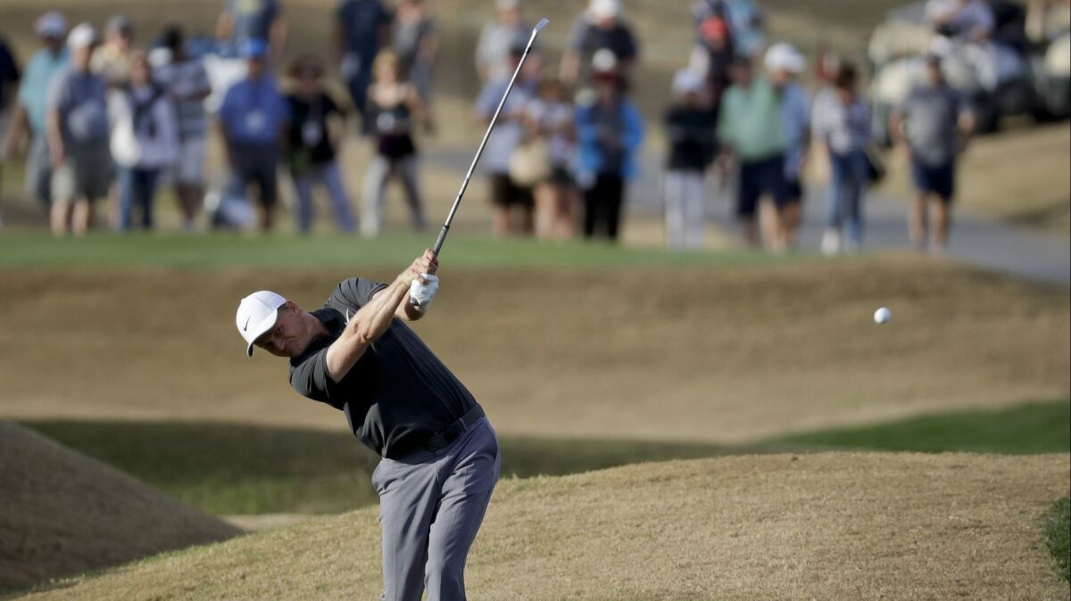 Adam Long hits from rough on the 18th hole during the final round of the Desert Classic golf tournament on Sunday.