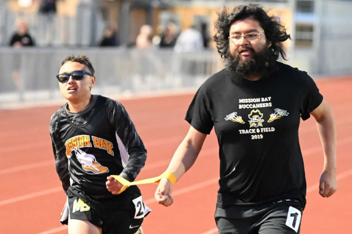 Mission Bay High freshman Chris Adamson running in a track meet with his guide runner and classroom aide David Cervantes.