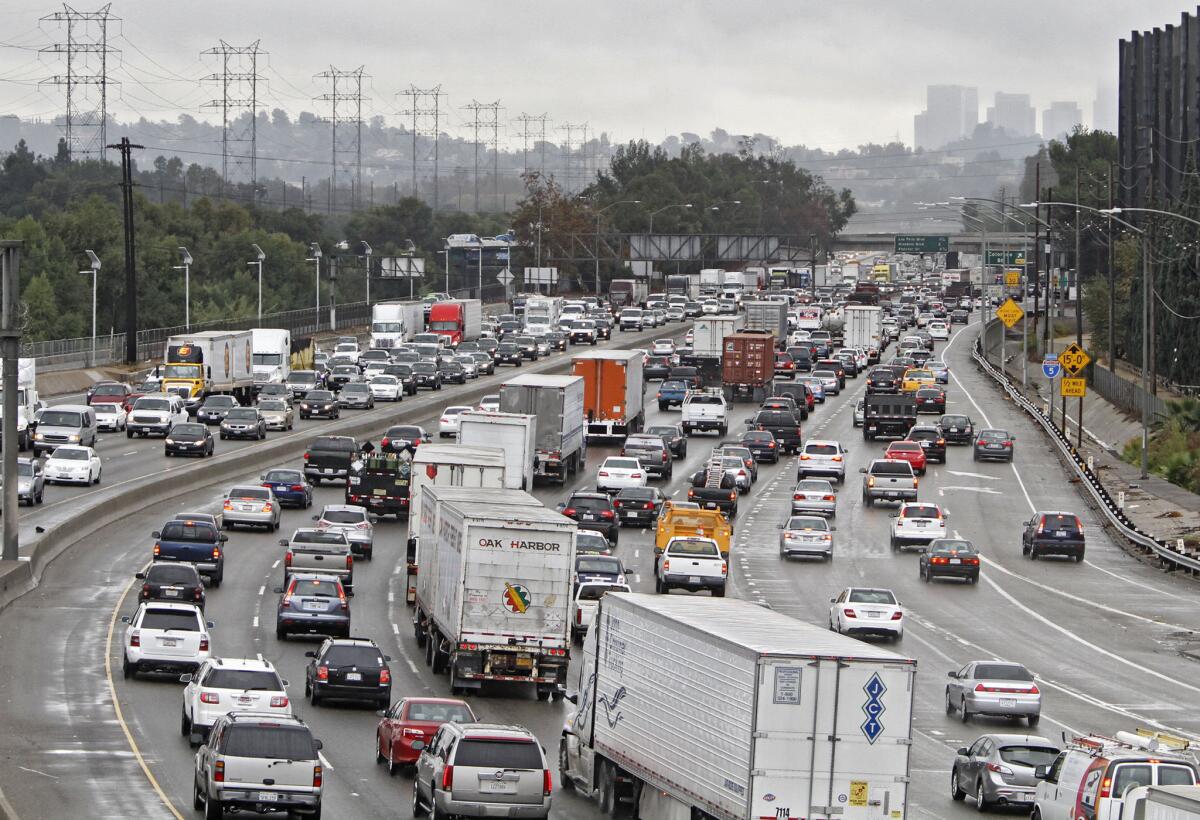 With downtown L.A. in the background, traffic moves slowly on a rainy morning on the southbound 5 Freeway from Burbank at the 134 Freeway near the Glendale-Los Angeles border on Thursday, Nov. 21, 2013.