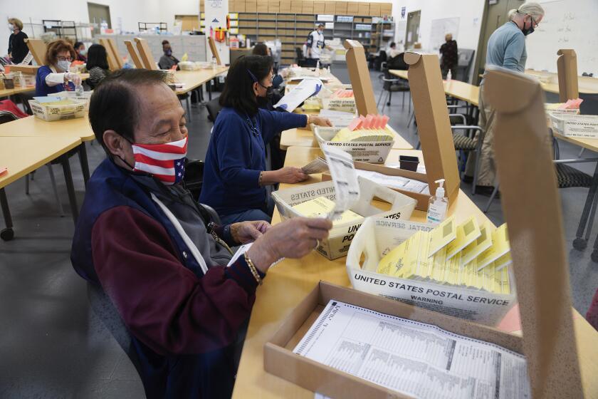 Workers opened mail-in primary ballots at the Registrar of Voters in Kearny Mesa on Tuesday.