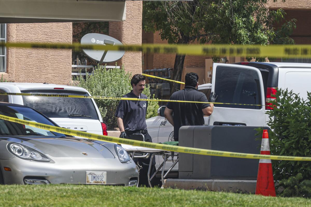 North Las Vegas Police are seen from behind police tape at an apartment complex in North Las Vegas.