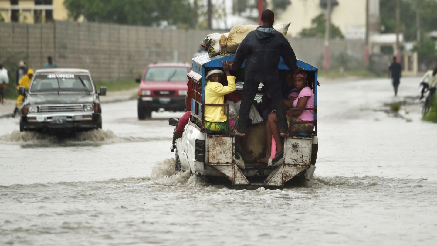 Public transportation known as a tap tap crosses the water left by heavy rains in Port-au-Prince, as Hurricane Matthew makes landfall in southwestern Haiti early Tuesday.