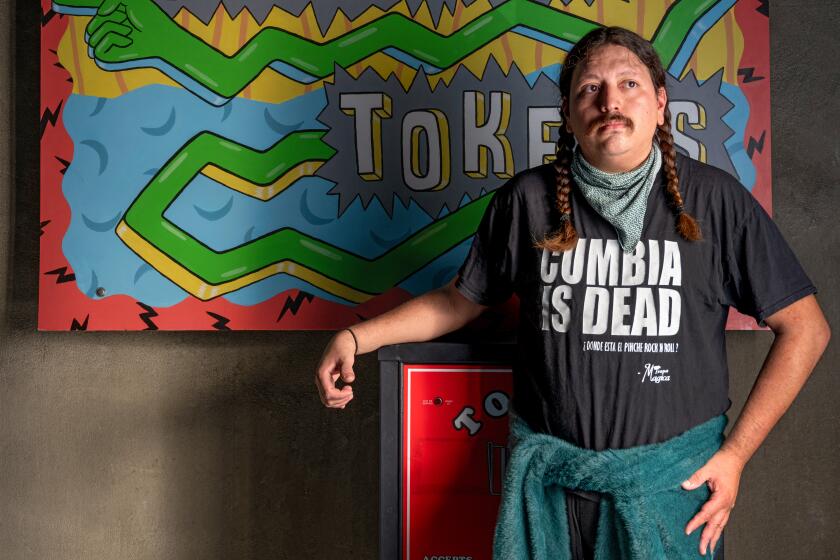 LOS ANGELES, CA - OCTOBER 5: Chef Diego Argoti next to an arcade token machine in Button Mash on Friday, October 5, 2023 in Los Angeles, CA. (Ron De Angelis / For The Times)