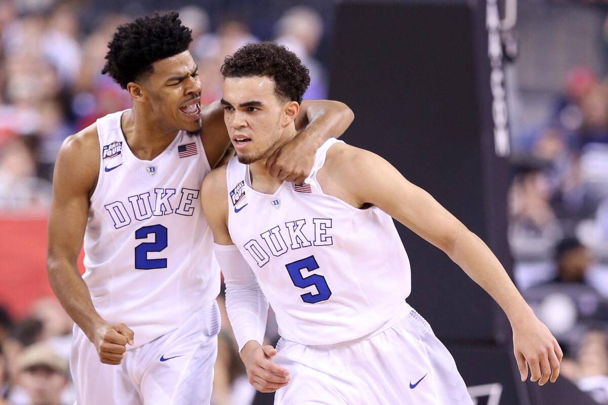 Duke guards Quinn Cook (2) and Tyus Jones (5) celebrate after a play in the first half of a game against Michigan State during the Final Four of the NCAA tournament on April 4.