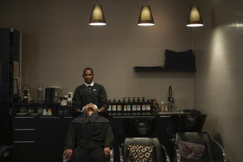 A customer has his hair shampooed in a hairdressing salon, in Paris, Wednesday, March 27, 2024. French lawmakers are debating a bill Thursday that would ban discrimination over the texture, length, color or style of someone's hair. (AP Photo/Thibault Camus)