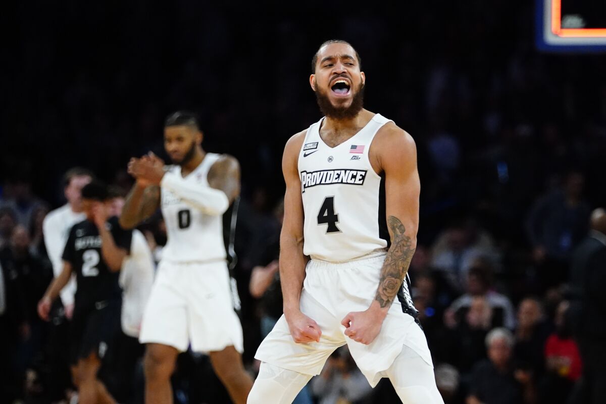 Providence's Jared Bynum (4) and Nate Watson (0) celebrate after an NCAA college basketball game against Butler at the Big East conference basketball tournament on Thursday, March 10, 2022, in New York. Providence won 65-61. (AP Photo/Frank Franklin II)