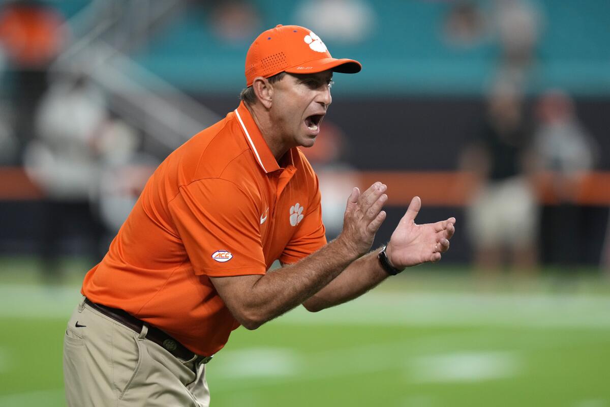 Dabo Swinney shouts and prepares to clap his hands.
