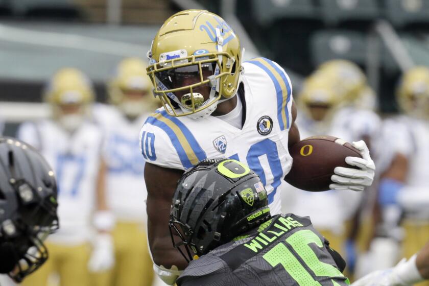 UCLA's Demetric Felton, left, is tackled by Oregon's Bennett Williams during the first quarter.