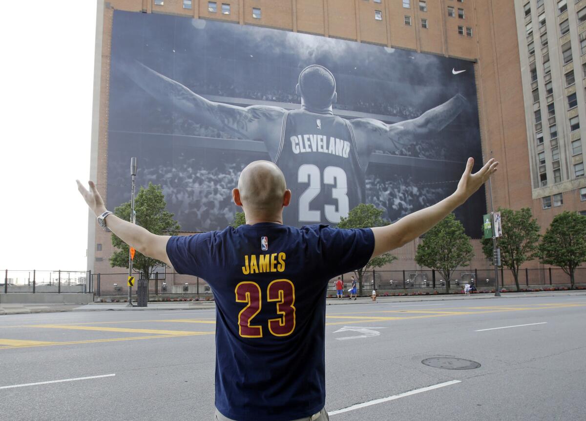 Four years later, LeBron James once again graces a banner on a building across from the Quicken Loans Arena.