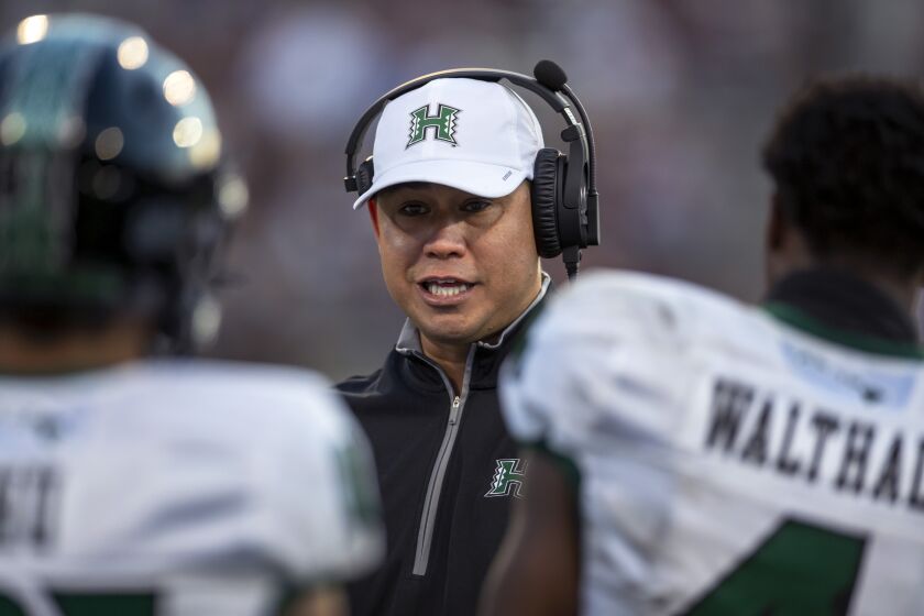 Hawaii coach Timmy Chang talks to his players during the first half of an NCAA college football game against New Mexico State in Las Cruces, N.M., Saturday, Sept. 24, 2022. (AP Photo/Andres Leighton)