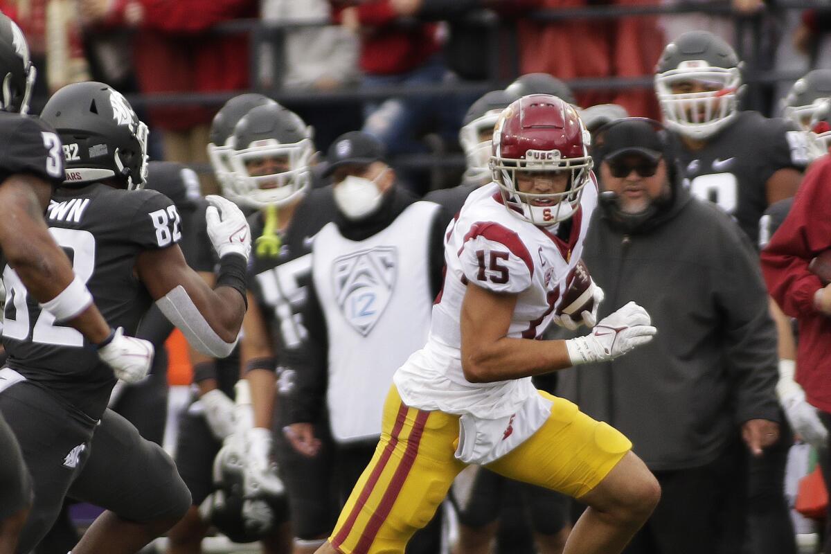 USC wide receiver Drake London runs with the ball while being chased by Washington State linebacker Travion Brown.