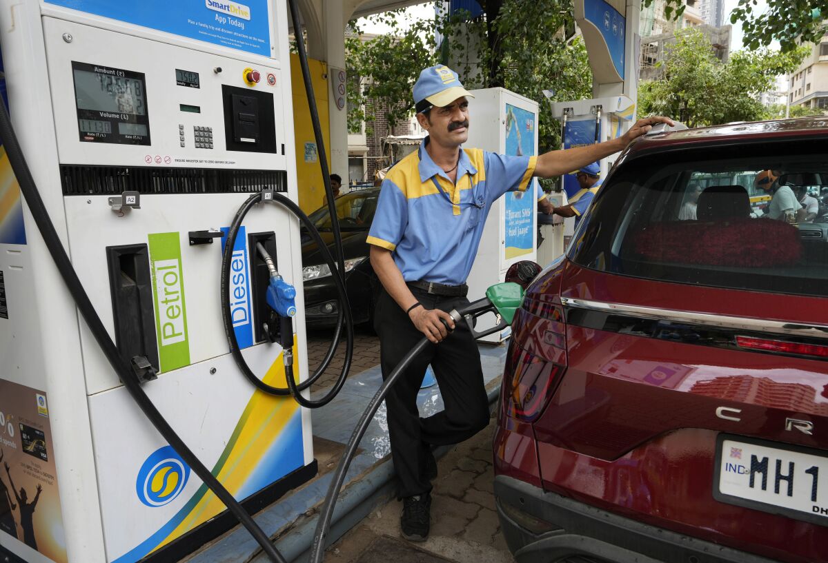 An employee of a Bharat petroleum fuel station fills petrol in a vehicle in Mumbai, India, Saturday, June 11, 2022. India and other Asian nations are becoming an increasingly vital source of oil revenues for Moscow as the U.S. and other Western countries cut their energy imports from Russia in line with sanctions over its war on Ukraine. (AP Photo/Rajanish kakade)