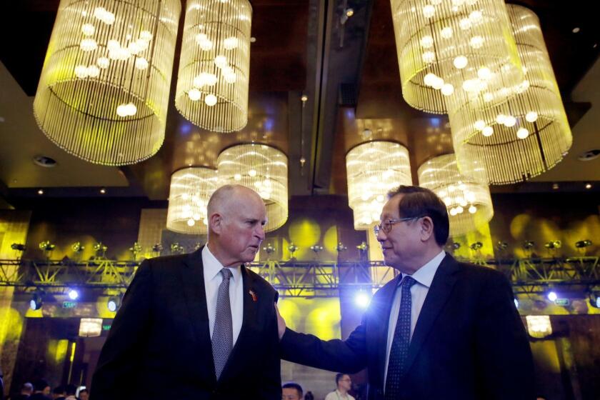 California Gov. Jerry Brown, left, chats with China's Science and Technology Minister Wan Gang as they attend the Clean Energy Ministerial International Forum on Electric Vehicle Pilot Cities and Industrial Development, at a hotel in Beijing, Tuesday, June 6, 2017. (AP Photo/Andy Wong)