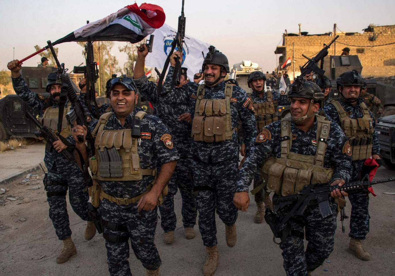 Members of the Iraqi federal police forces celebrate in the Old City of Mosul on July 10, 2017, after the government's announcement of the "liberation" of the embattled city from Islamic State fighters.