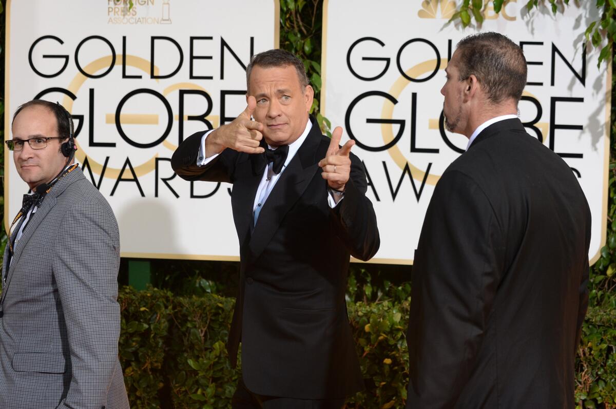 Tom Hanks, center, arrives at the 71st Golden Globe Awards at the Beverly Hilton Hotel.