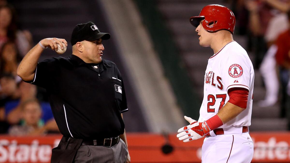 Angels center fielder Mike Trout speaks with home plate umpire Eric Cooper after being called out on strikes to end the fourth inning with the bases loaded against the Baltimore Orioles on Monday.