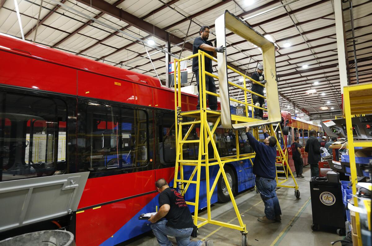 Workers at the BYD plant in Lancaster build electric buses.