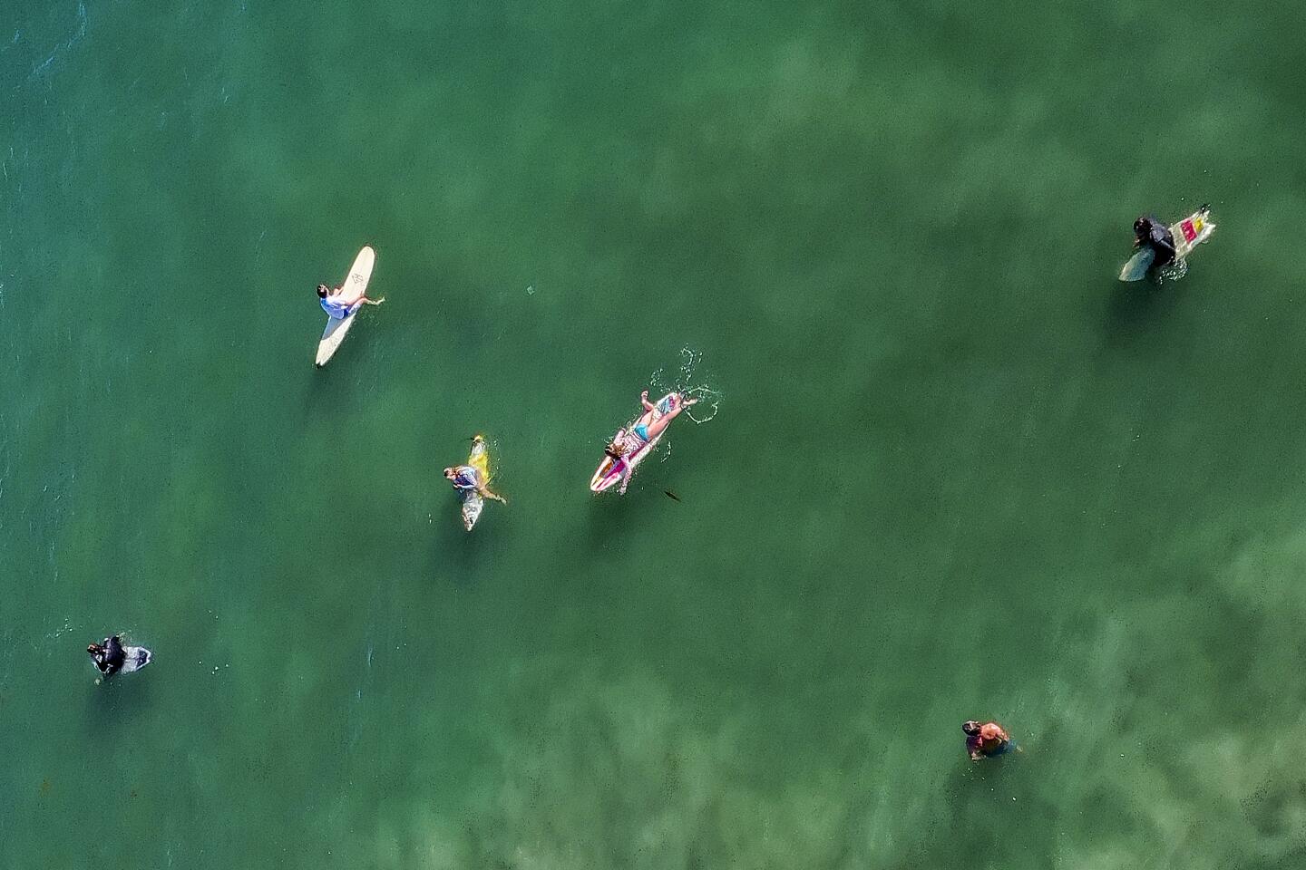 Aerial view shows surfers waiting for a wave in Newport Beach