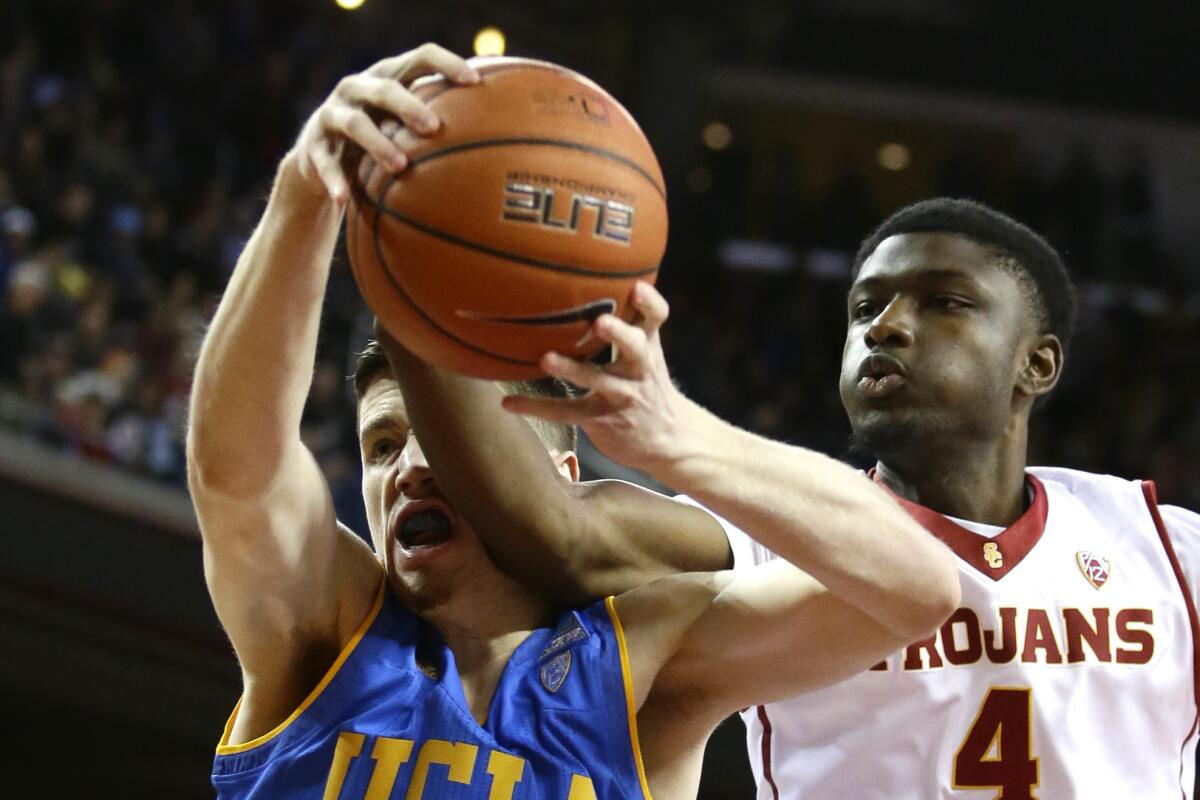 UCLA forward TJ Leaf, left, battles for a rebound with USC forward Chimezie Metu during first half action at the Galen Center.
