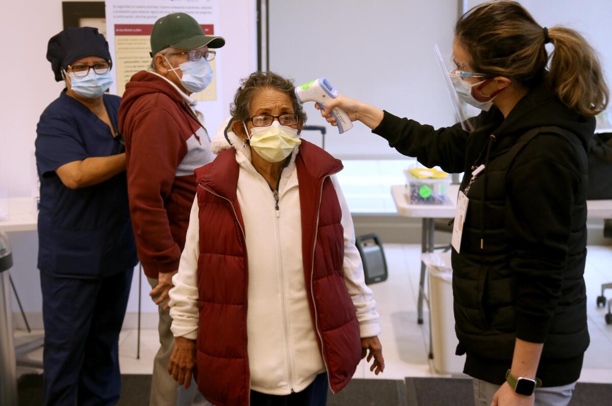 A patient has her temperature checked