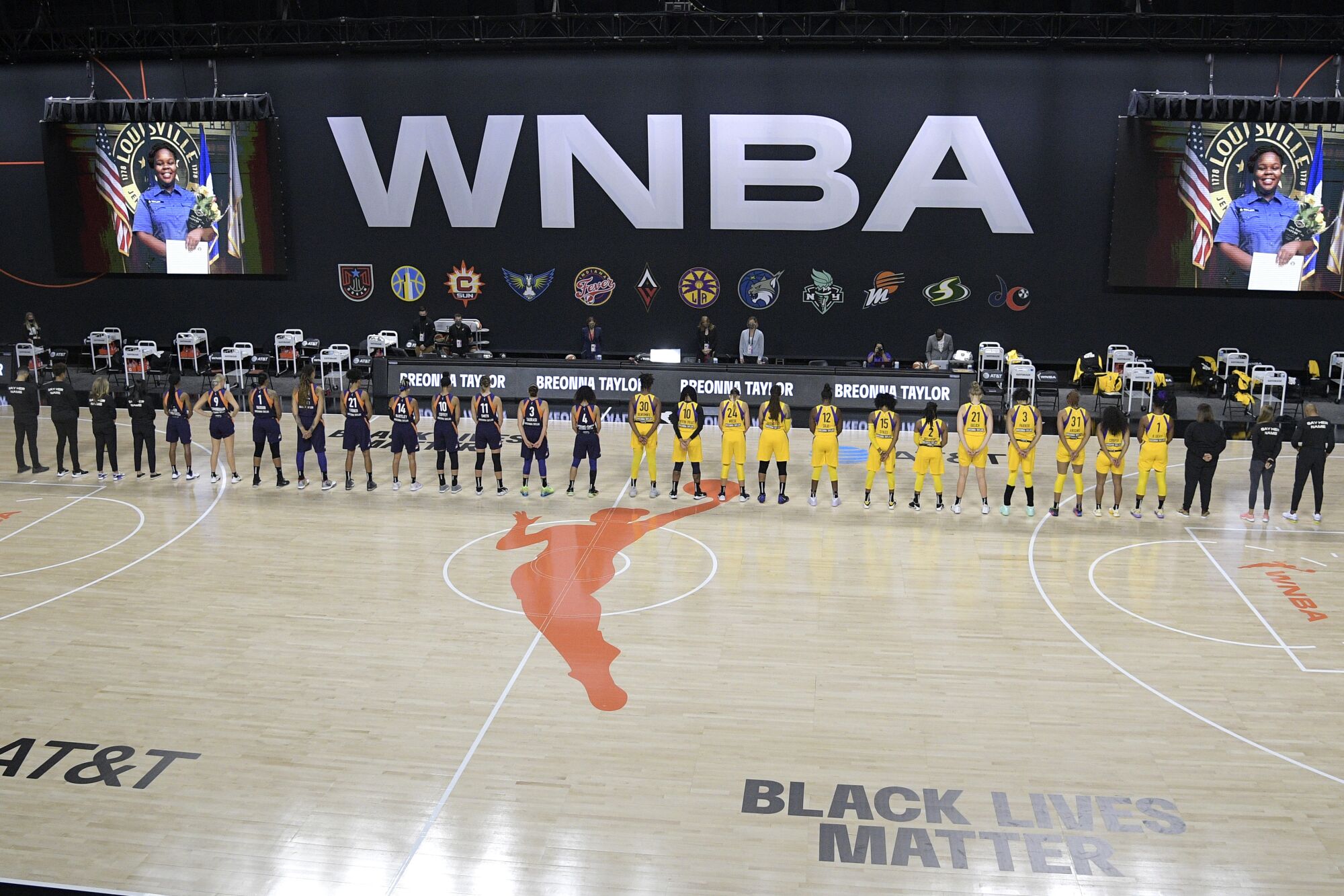 Members of the Phoenix Mercury, left, and Los Angeles Sparks stand for a moment of silence for Breonna Taylor.
