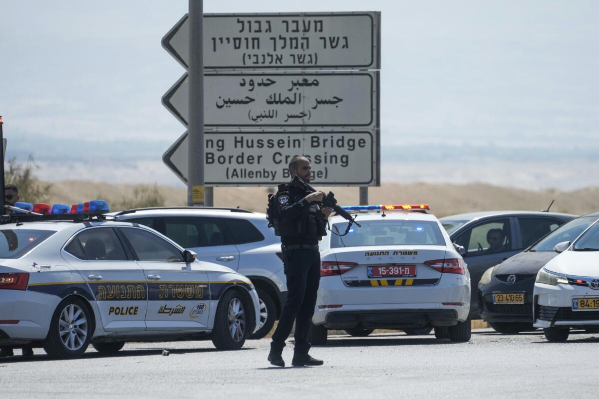 Israeli police stand guard near police vehicles.