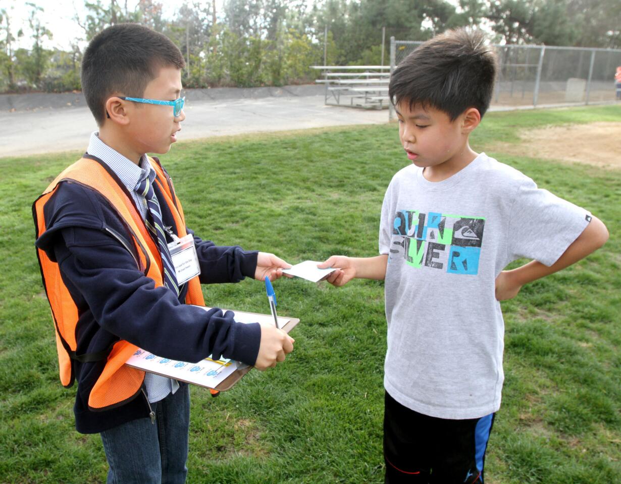 La Cañada Elementary School's Principal for a Day and fifth grader Michael Kwan, left, gives second grader Chris Bae a Way to B! award during recess at the La Cañada Flintridge school on Tuesday, January 19, 2016.