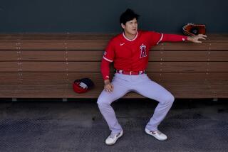The Angels' Shohei Ohtani sits in the dugout prior to a spring training game on Feb. 23