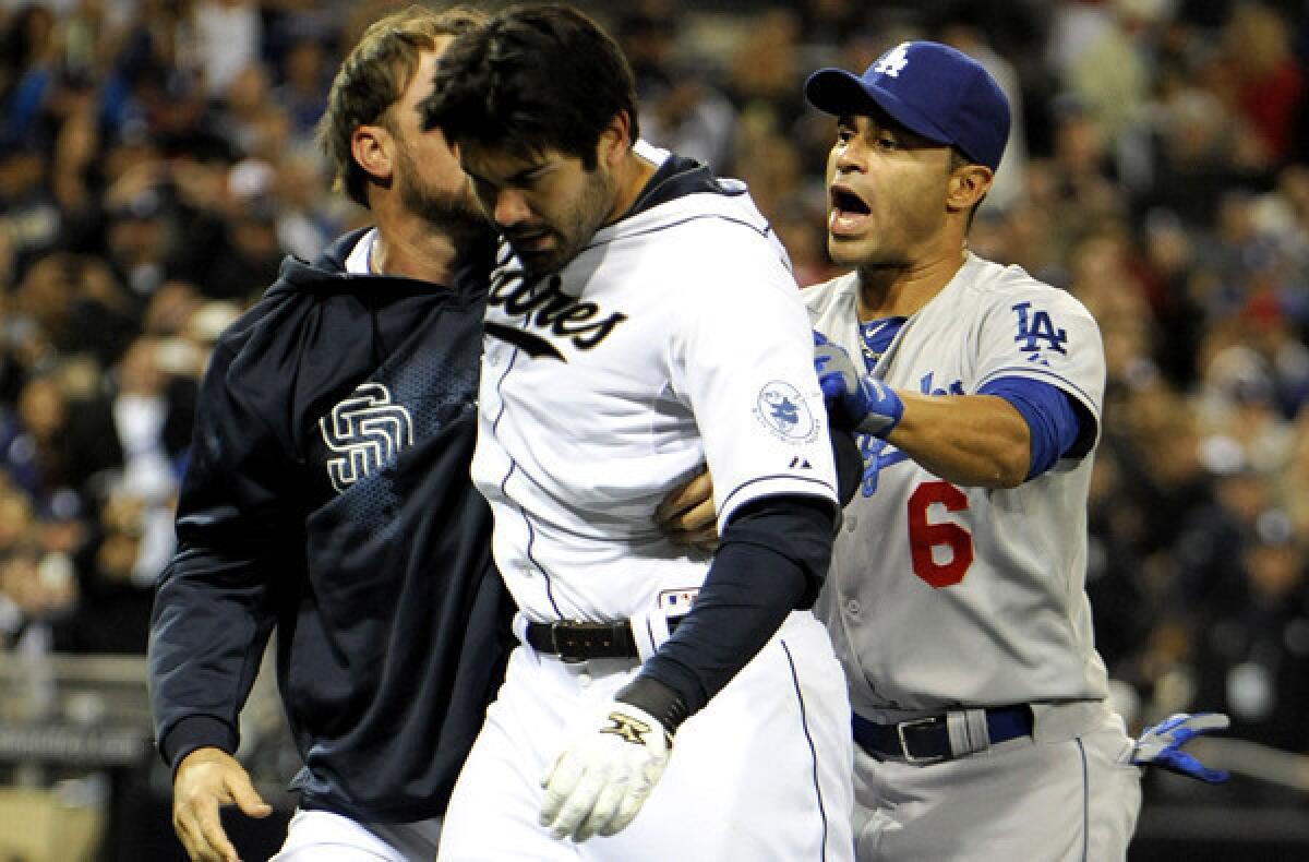 Padres reserve outfielder Mark Kotsay and Dodgers utility player Jerry Hairston Jr. escort San Diego's Carlos Quentin off the field after he charged the mound and tackled starting pitcher Zack Greinke, who hit him with a pitch in the sixth inning Thursday night.