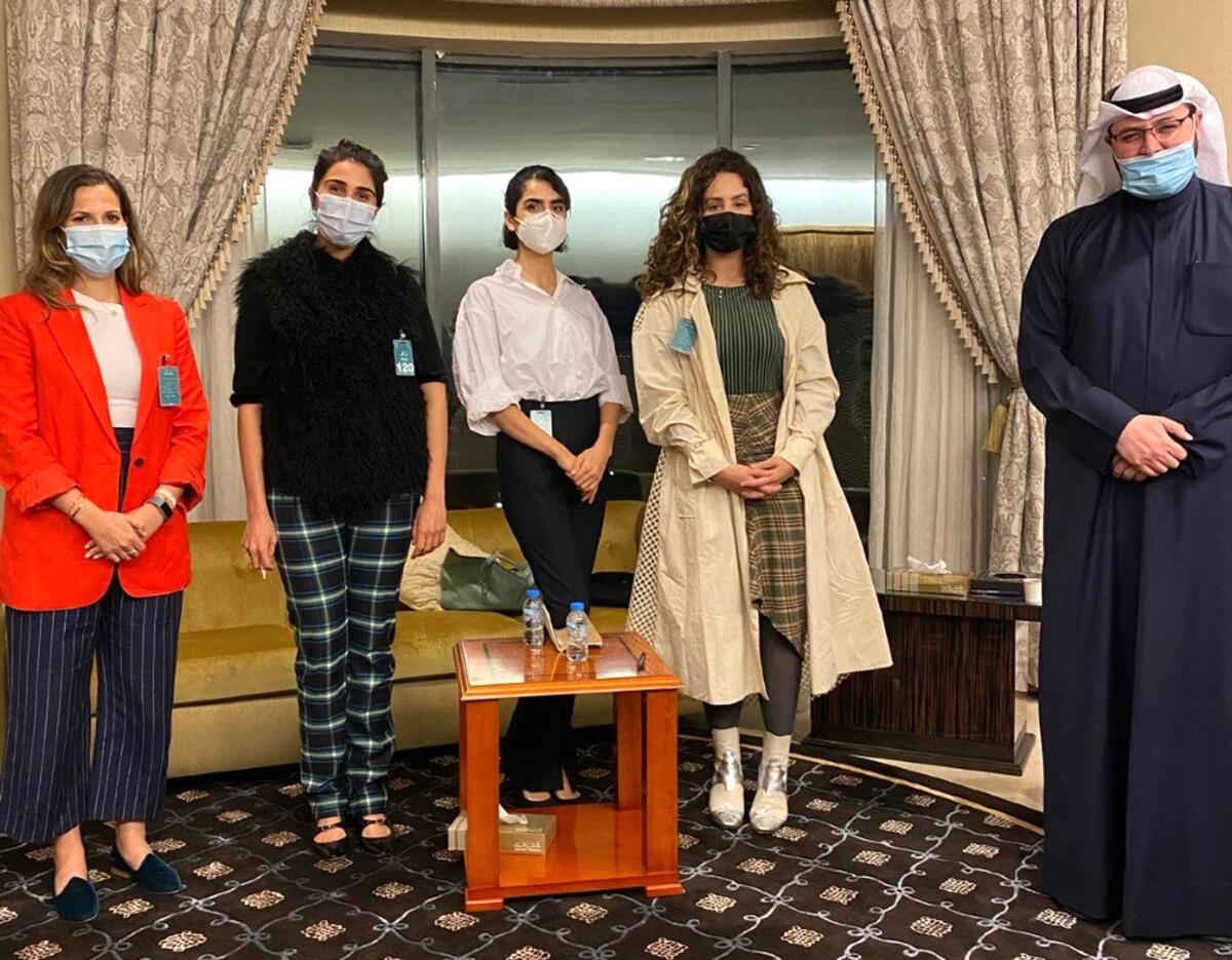In this March 4, 2021, photo provided by the Lan Asket campaign, the founders, from left, Lina al-Qaddoumi, Najeeba Hayat, Shayma Shamo and Ascia al-Faraj, stand beside Abdulaziz al-Saqabi, one of the Kuwaiti politicians who has proposed an amendment to the penal code to define and punish sexual harassment in Kuwait City, Kuwait. (Lan Asket via AP)