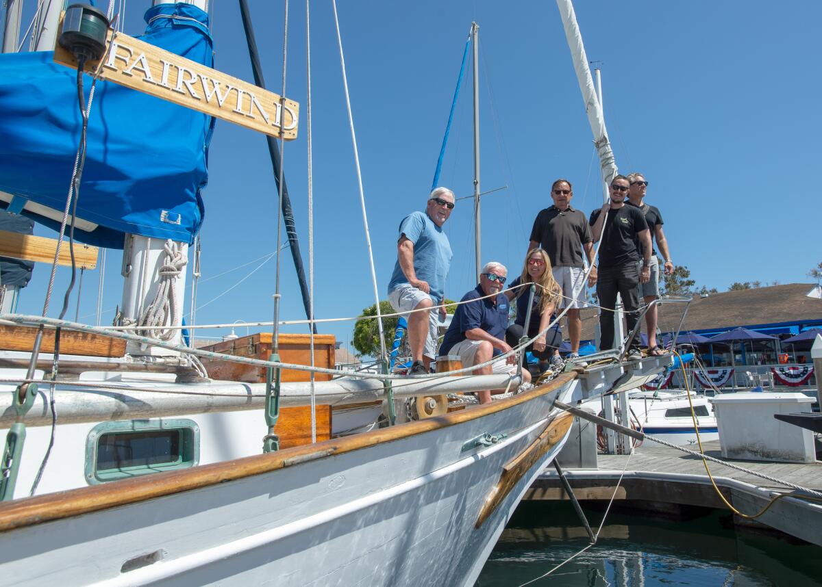 Longtime friends of the late Tim "Skipper" Bercovitz stand aboard his boat.
